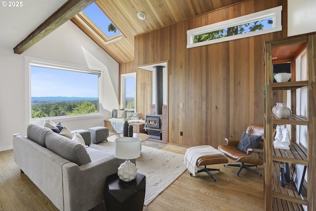 175 SW 85th Ave, Portland, OR 97225 - living room with a wood stove, a skylight, wood walls, healthy amount of natural light, and wood finished floors