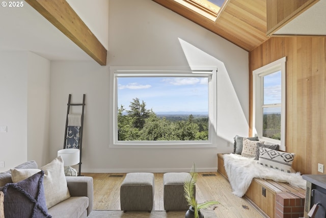 175 SW 85th Ave, Portland, OR 97225 - living room featuring lofted ceiling, a skylight, light wood-style flooring, and wood walls