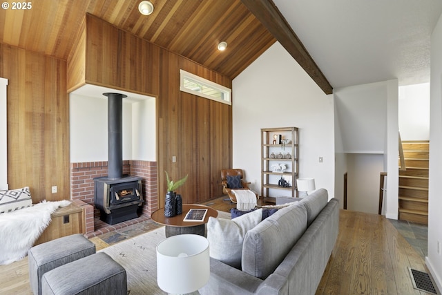 175 SW 85th Ave, Portland, OR 97225 - living room with lofted ceiling, wood finished floors, a wood stove, stairs, and wooden walls