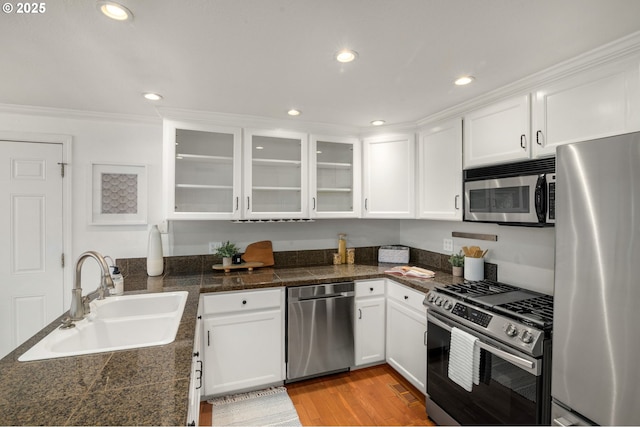 kitchen with tile counters, white cabinets, stainless steel appliances, and a sink