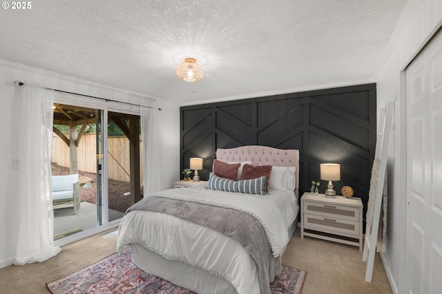 bedroom featuring a textured ceiling, carpet, and access to outside