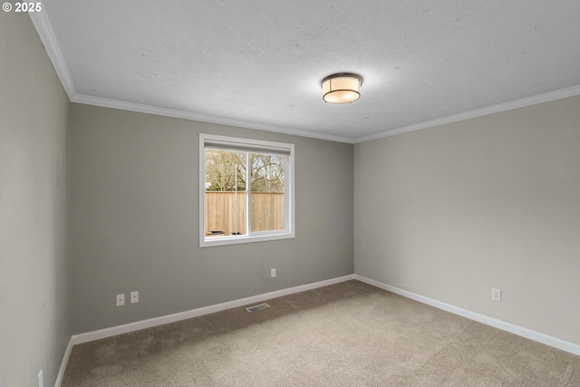 carpeted empty room featuring visible vents, a textured ceiling, crown molding, and baseboards