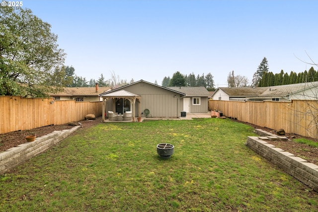 back of property with a gazebo, a yard, a patio area, and a fenced backyard