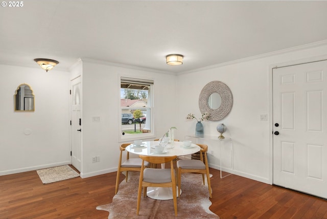 dining room featuring wood finished floors, baseboards, and ornamental molding