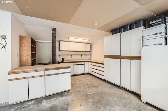 9843 SW 57th Ave, Portland, OR 97219 - kitchen featuring unfinished concrete flooring, white cabinets, and light countertops