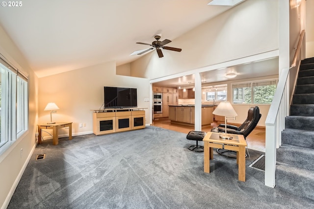 9843 SW 57th Ave, Portland, OR 97219 - living area featuring stairs, baseboards, ceiling fan, light colored carpet, and high vaulted ceiling