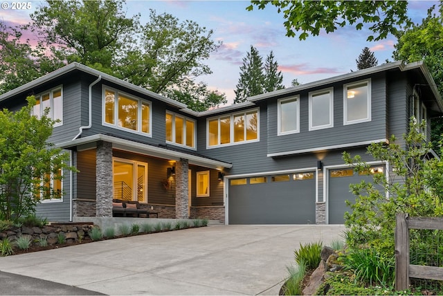 927 SW Maplecrest Ct, Portland, OR 97219 - view of front of house with stone siding, an attached garage, and concrete driveway