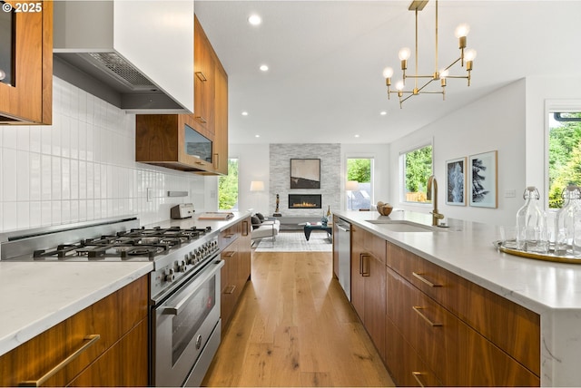 927 SW Maplecrest Ct, Portland, OR 97219 - kitchen with appliances with stainless steel finishes, modern cabinets, a sink, premium range hood, and plenty of natural light