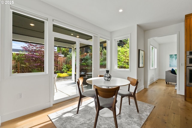 927 SW Maplecrest Ct, Portland, OR 97219 - dining space with healthy amount of natural light, baseboards, light wood-style floors, and recessed lighting