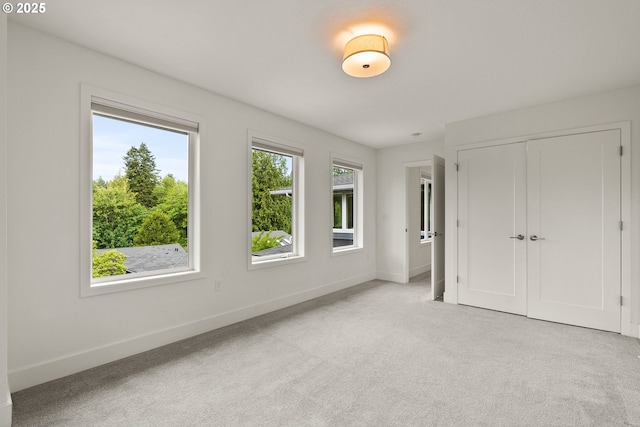 927 SW Maplecrest Ct, Portland, OR 97219 - unfurnished bedroom with baseboards, light colored carpet, and a closet