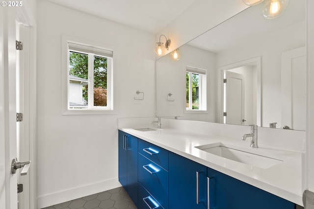 927 SW Maplecrest Ct, Portland, OR 97219 - bathroom featuring healthy amount of natural light, double vanity, tile patterned flooring, and baseboards