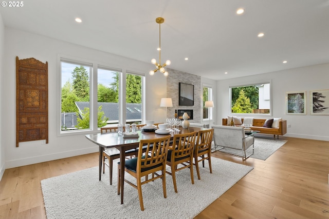 927 SW Maplecrest Ct, Portland, OR 97219 - dining area with a fireplace, baseboards, recessed lighting, and light wood-style floors