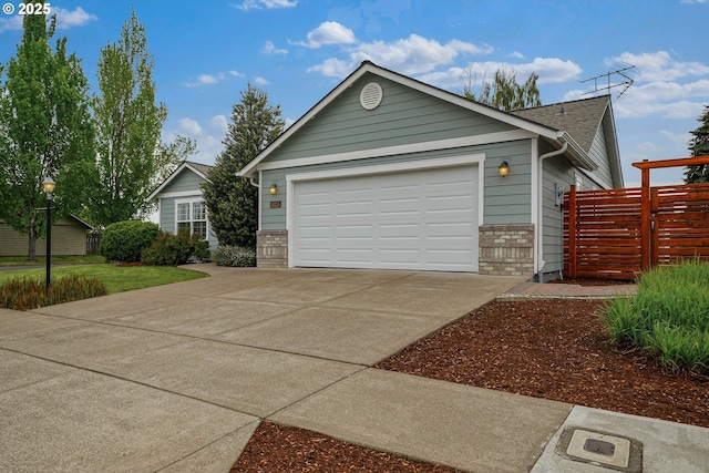 ranch-style home with driveway, fence, and a garage