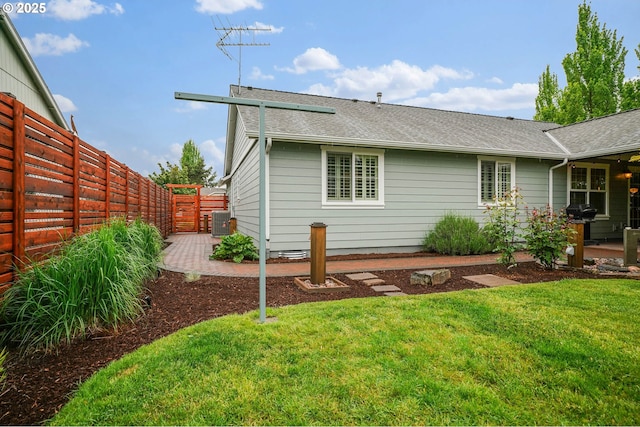 back of house featuring a shingled roof, a patio area, and central AC unit