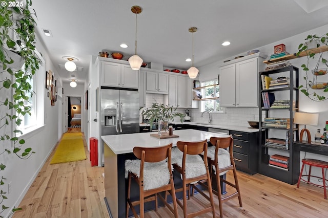 9115 N Richmond Ave, Portland, OR 97203 - kitchen with a sink, light countertops, tasteful backsplash, light wood-style flooring, and pendant lighting