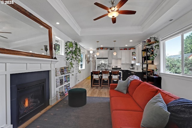 9115 N Richmond Ave, Portland, OR 97203 - living room with a ceiling fan, light wood-style flooring, a tray ceiling, a glass covered fireplace, and recessed lighting