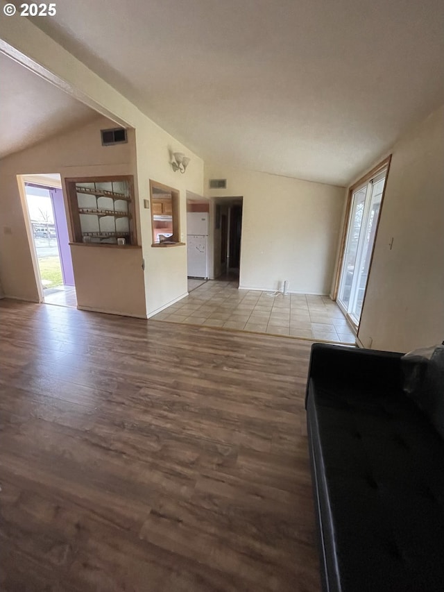 unfurnished living room featuring light hardwood / wood-style flooring and lofted ceiling