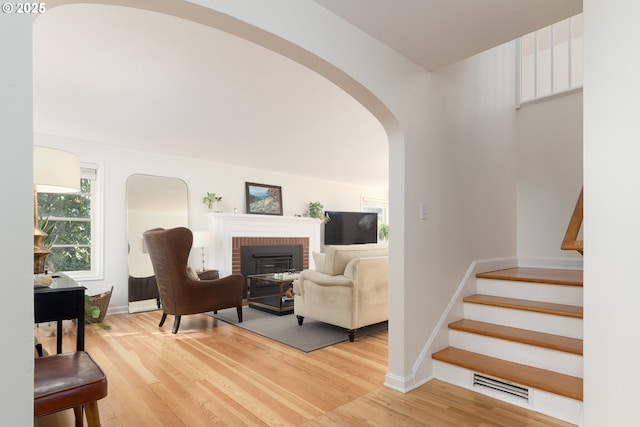 living area with visible vents, stairway, baseboards, and wood finished floors