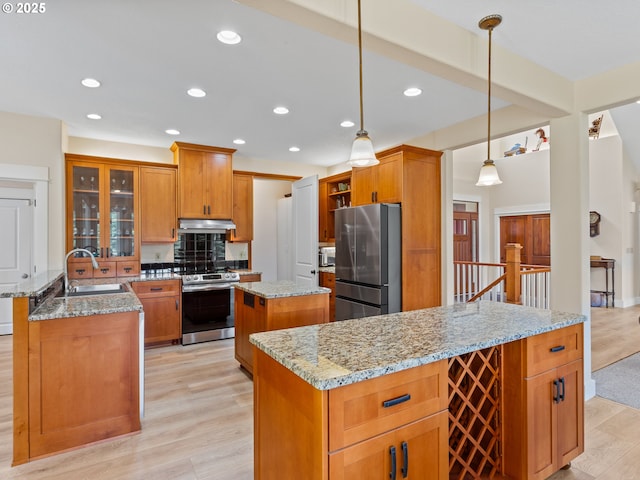 21800 S Green Mountain Rd, Colton, OR 97017 - kitchen with stainless steel appliances, under cabinet range hood, a kitchen island, open shelves, and brown cabinetry
