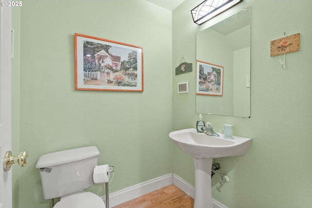 bathroom featuring wood-type flooring and toilet