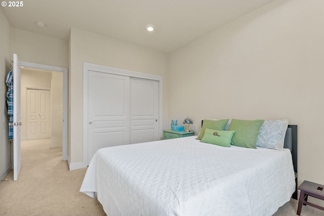 bedroom featuring light carpet and a closet