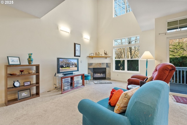 carpeted living room with a fireplace and a high ceiling