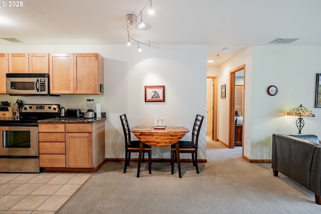 606 NW Naito Pkwy Unit A14, Portland, OR 97209 - kitchen with dark countertops, visible vents, appliances with stainless steel finishes, and light colored carpet