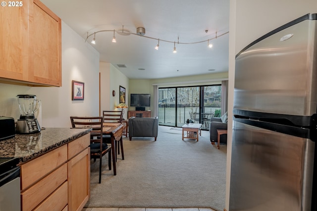 606 NW Naito Pkwy Unit A14, Portland, OR 97209 - kitchen featuring visible vents, light brown cabinets, light carpet, freestanding refrigerator, and open floor plan