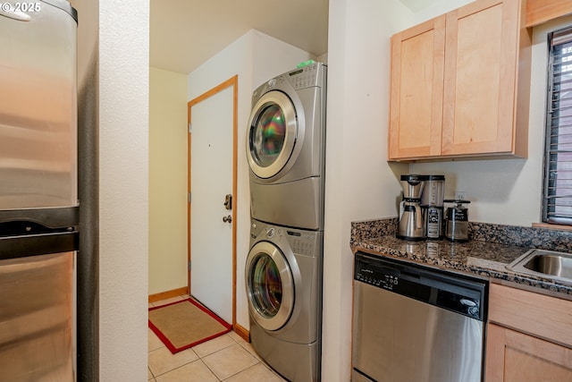 606 NW Naito Pkwy Unit A14, Portland, OR 97209 - laundry area featuring a sink, stacked washing maching and dryer, and light tile patterned floors