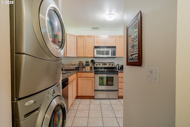 606 NW Naito Pkwy Unit A14, Portland, OR 97209 - kitchen featuring visible vents, light brown cabinetry, stacked washing maching and dryer, and appliances with stainless steel finishes