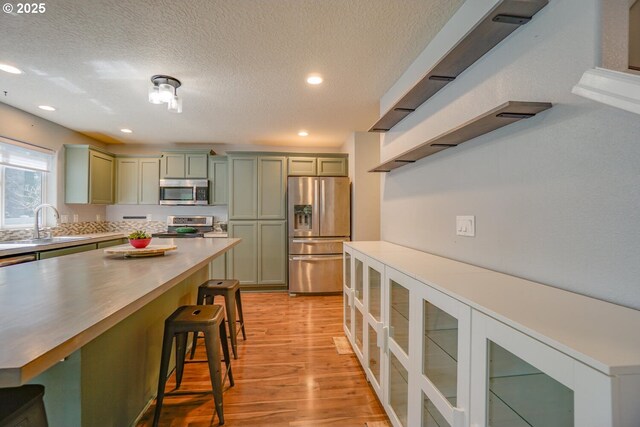 2301 NW 15th St, Battle Ground, WA 98604 - kitchen with a breakfast bar, recessed lighting, light wood-style flooring, appliances with stainless steel finishes, and a sink
