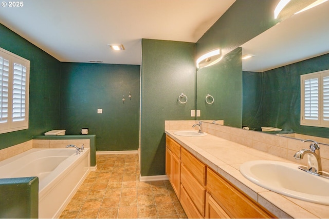 2301 NW 15th St, Battle Ground, WA 98604 - bathroom featuring a sink, a bath, double vanity, and baseboards