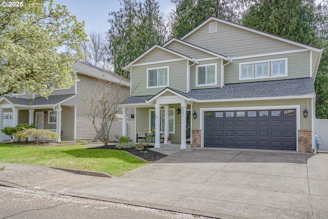 2301 NW 15th St, Battle Ground, WA 98604 - view of front facade with concrete driveway, a front yard, stone siding, and a garage