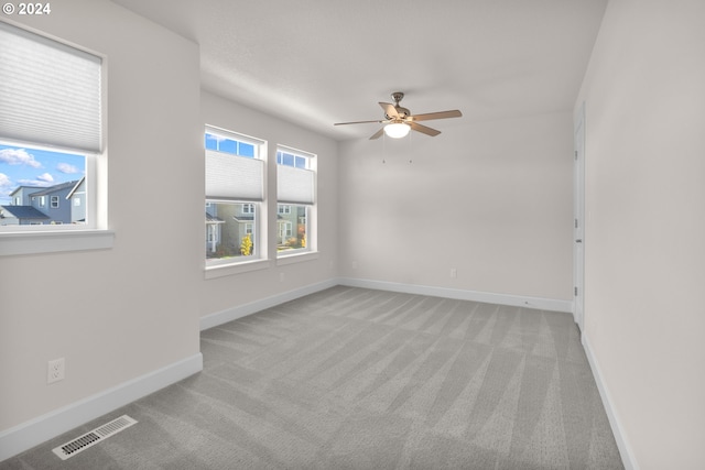 carpeted spare room with ceiling fan