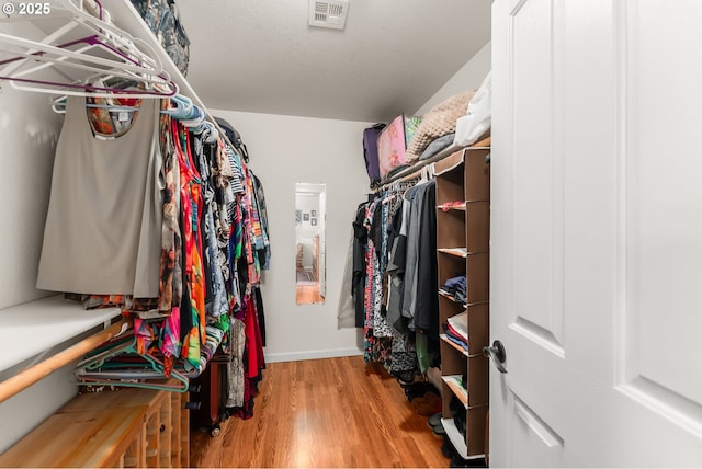 walk in closet with wood finished floors and visible vents