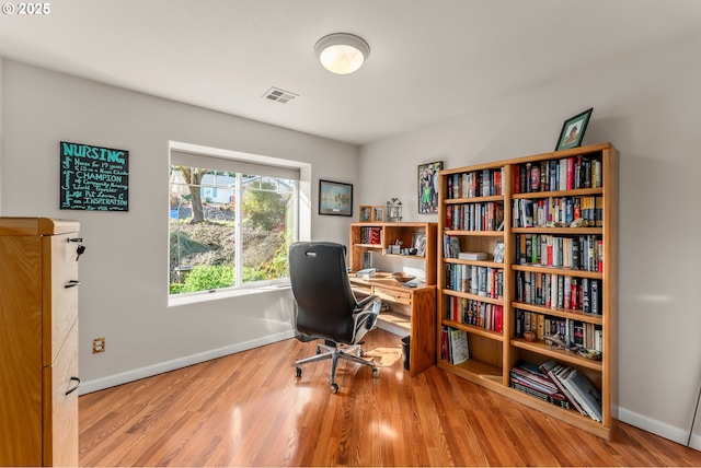 office featuring wood finished floors, visible vents, and baseboards