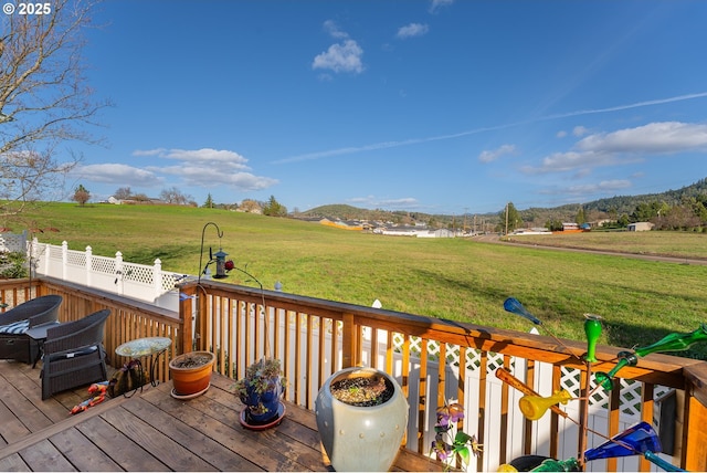 deck with a rural view and a yard