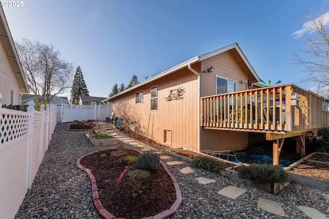 view of property exterior with a fenced backyard and a wooden deck