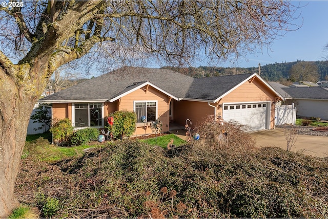 ranch-style house with a garage, driveway, roof with shingles, and fence