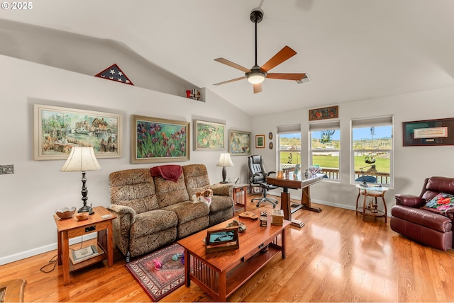 living room featuring lofted ceiling, light wood-style flooring, baseboards, and ceiling fan