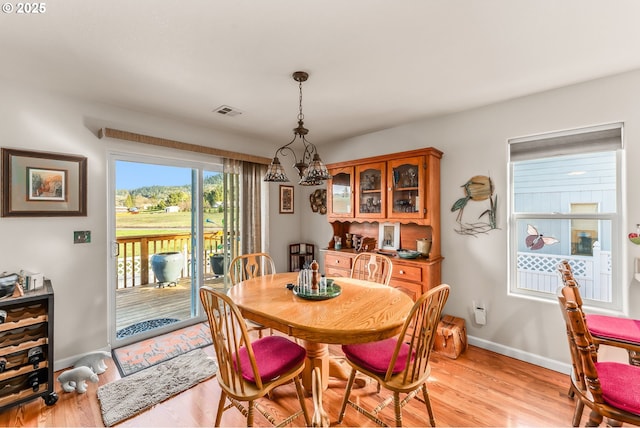 dining space with light wood-style floors, baseboards, and visible vents