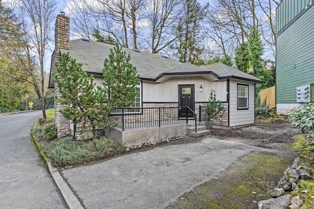 802 NW 5th Cir, Camas, WA 98607 - view of front facade with stone siding, a chimney, and a shingled roof