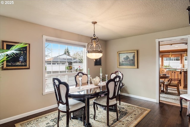 dining room featuring dark wood-style floors, a textured ceiling, and baseboards