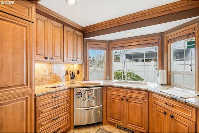 kitchen featuring dishwasher, backsplash, a sink, and a wealth of natural light