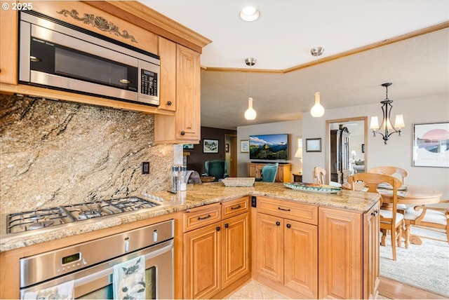 kitchen featuring a peninsula, stainless steel appliances, decorative backsplash, and decorative light fixtures