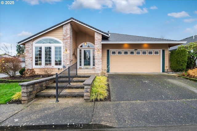 view of front of house with driveway, brick siding, and an attached garage