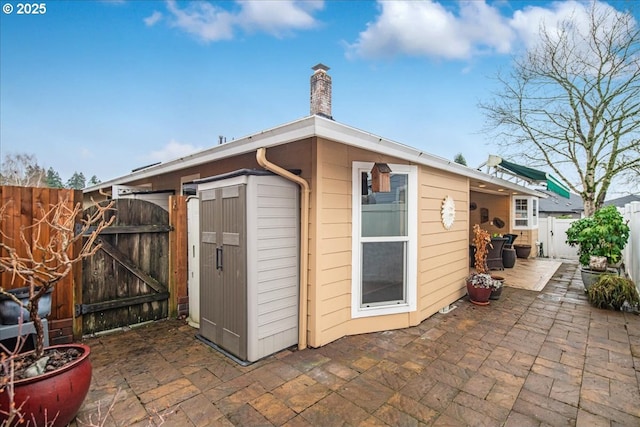 view of outbuilding featuring a gate and fence