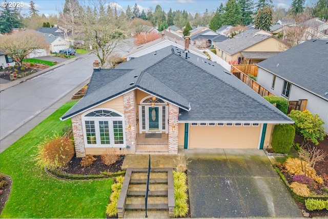 traditional-style house with an attached garage, brick siding, concrete driveway, roof with shingles, and a residential view