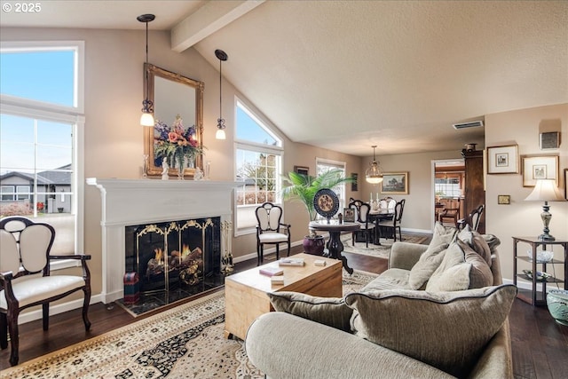 living room with visible vents, a premium fireplace, wood finished floors, beamed ceiling, and baseboards