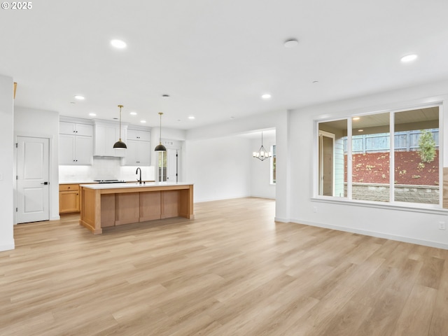 kitchen featuring open floor plan, light countertops, light wood-style flooring, and recessed lighting